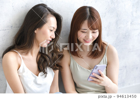 スマホを一緒に見ている女性二人 スマホを一緒に見ている女性二人 94613450