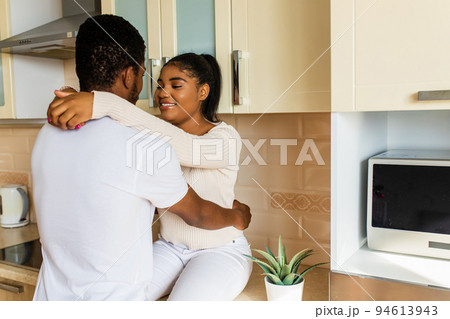 Young happy mixed race couple spending their time at home in the kitchen Young happy mixed race couple spending their time at home in the kitchen 94613943