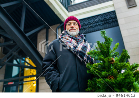 happy mature man in winter christmas market outdoors with cityscape in the background happy mature man in winter christmas market outdoors with cityscape in the background 94614612