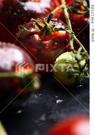 Macro of whole wet black cherry tomato Macro of whole wet black cherry tomato 94615588