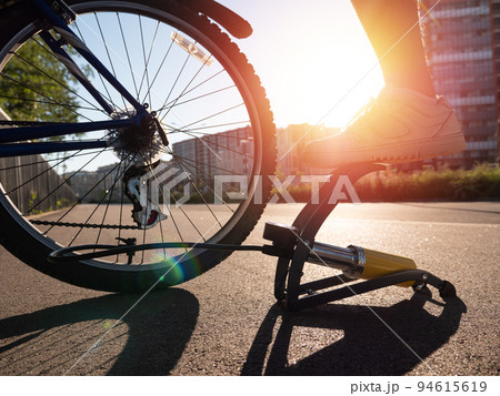 Man inflating bike tire outdoors. Pumping up bicycle tyre Man inflating bike tire outdoors. Pumping up bicycle tyre 94615619