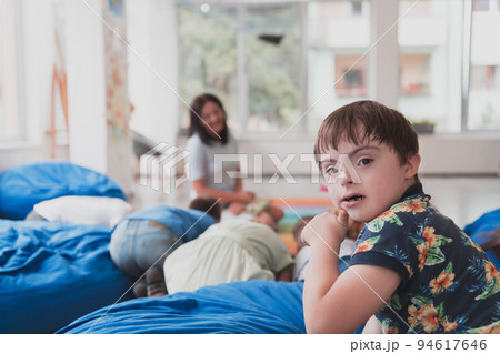 A boy with Down's syndrome spend time together in a preschool institution and play games A boy with Down's syndrome spend time together in a preschool institution and play games 94617646