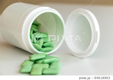 倒れた容器と緑色の粒ガム 倒れた容器と緑色の粒ガム 94618903