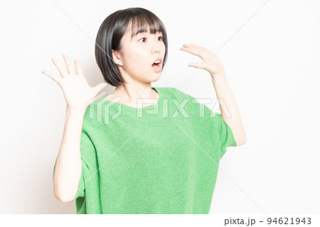 白背景の前で驚いたポーズをする若い女性 白背景の前で驚いたポーズをする若い女性 94621943