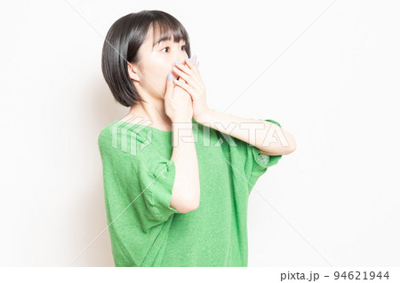 白背景の前で驚いたポーズをする若い女性 94621944