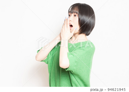 白背景の前で驚いたポーズをする若い女性 94621945
