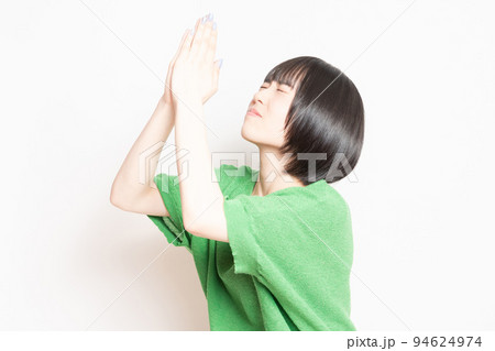 白バックの前で、謝っている若い女性 94624974