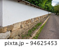 道に沿って続く日本家屋の伝統的な白壁 94625453