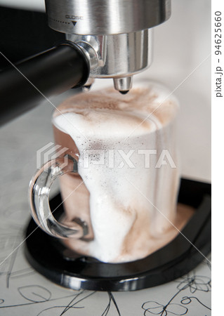 Coffee machine overfilled cup with coffee close up 94625660