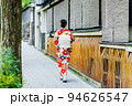 着物姿で竹矢来が並ぶ京都の街並みを歩く女性 94626547