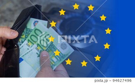 Mens hands with a purse and euro banknotes on the background of a gas stove. Mens hands with a purse and euro banknotes on the background of a gas stove. 94627496