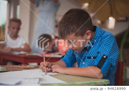 Cute girl and boy sit and draw together in preschool institution 94628990