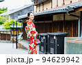 京都の街並みを歩く着物姿の女性 94629942