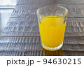 Orange juice drink, a close up of glass of tasty tropical juice beverage on wood table. 94630215
