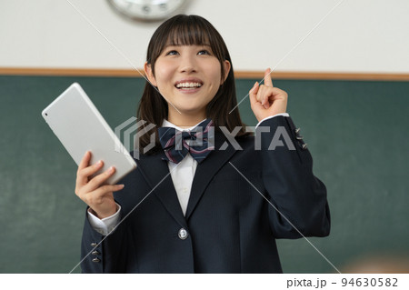 学校の教室でタブレットを手に発表をする女子高生 学校の教室でタブレットを手に発表をする女子高生 94630582