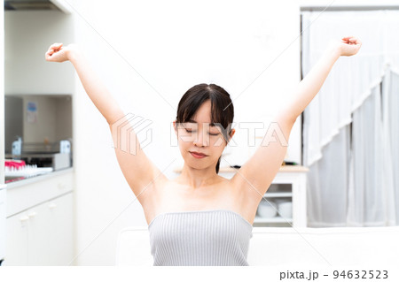 くつろいで背のびをする若い女性 くつろいで背のびをする若い女性 94632523