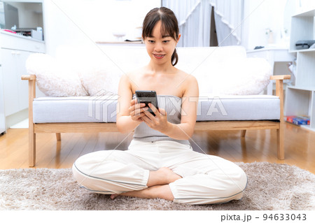 自宅でスマホを見る若い女性 自宅でスマホを見る若い女性 94633043