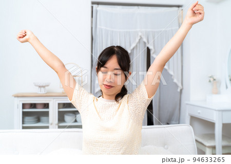 くつろいで背のびをする若い女性 くつろいで背のびをする若い女性 94633265