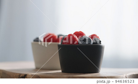 Fresh berries in bowl on linen napkin 94636523