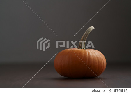 Small orange pumpkin on walnut wood table with copy space Small orange pumpkin on walnut wood table with copy space 94636612