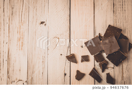 dark chocolate without sugar and gluten free for diabetics and allergics. Black chocolate broken into pieces lies on a white painted table in a rustic style. Dark toning. Copy space. dark chocolate without sugar and gluten free for diabetics and allergics. Black chocolate broken into pieces lies on a white painted table in a rustic style. Dark toning. Copy space. 94637676