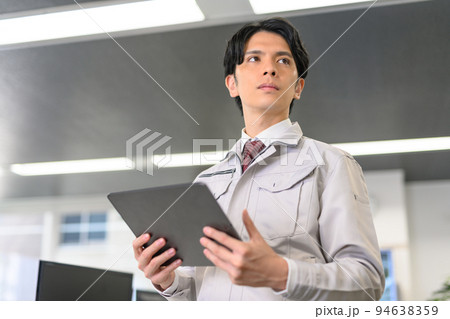 タブレットを持って作業をする若いエンジニア 94638359