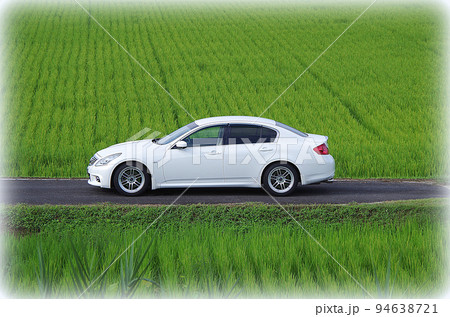 緑色の田んぼに映える白色のセダン（イラスト風） 94638721