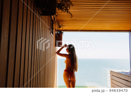 a slender,beautiful woman topless by the panoramic window in the sauna a slender,beautiful woman topless by the panoramic window in the sauna 94639470