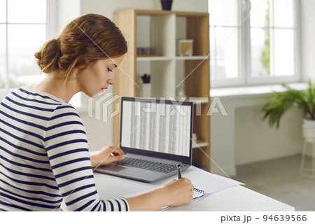 Woman office worker is working with spreadsheet on computers screens and making notes. 94639566