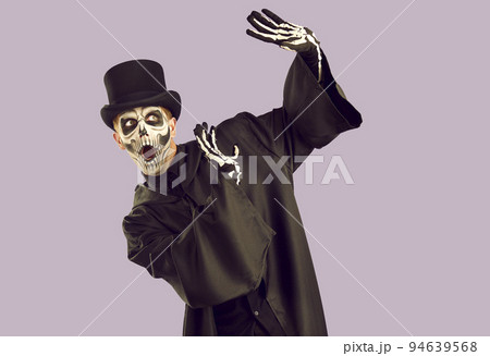 Halloween skeleton guy does protecting gesture and looks away with scared face expression 94639568