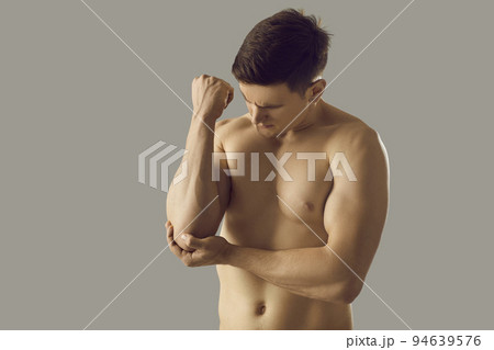 Toned man touch elbow suffer from acute pain Toned man touch elbow suffer from acute pain 94639576