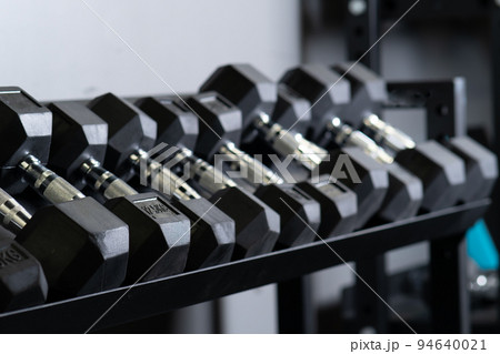 Dumbbell blurry home gym wall set storage rig sport, concept accessories gear in closeup and man healthy, fit muscle. Lifting , 94640021