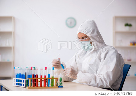 Young male chemist in drugs synthesis concept 94641769