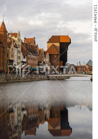 Ancient crane - zuraw Old town in Gdansk. The riverside on Granary Island reflection in Moltawa River. Visit Gdansk Poland Travel destination Ancient crane - zuraw Old town in Gdansk. The riverside on Granary Island reflection in Moltawa River. Visit Gdansk Poland Travel destination 94641911