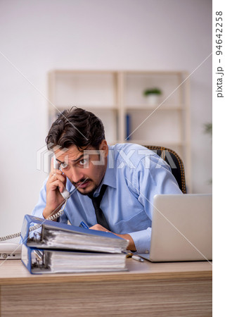 Young male employee working in the office Young male employee working in the office 94642258