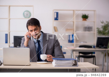 Young male employee drinking coffee during break 94642269