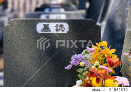 墓に手向けれれた花と墓誌 94642350