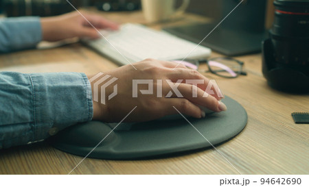 Woman working remotely on pc using mouse 94642690