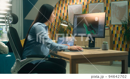 Female 3D designer modeling guitar on pc 94642702