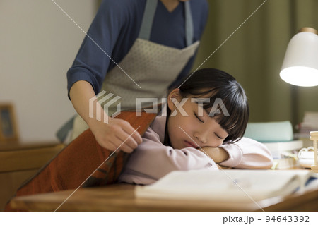 勉強机で居眠りをする娘に毛布をかける母親 中学生 高校生 94643392