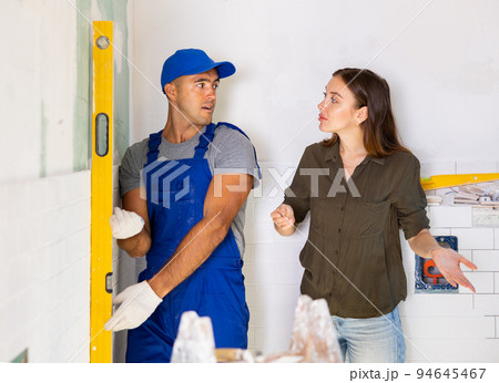 Woman dissatisfied with work done by the builder to renovate bathroom Woman dissatisfied with work done by the builder to renovate bathroom 94645467