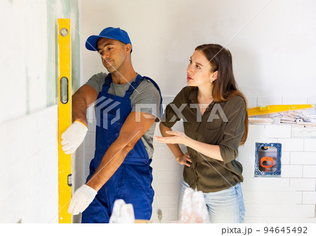 Woman dissatisfied with work done by the builder to renovate bathroom Woman dissatisfied with work done by the builder to renovate bathroom 94645492