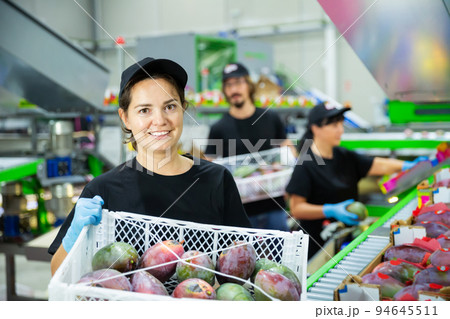 Woman carrying box with mangos at warehouse 94645511