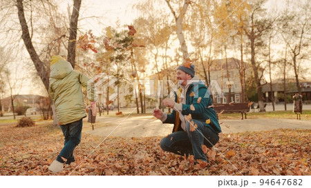 father and little child in an autumn park throw dry leaves up, happy family, live fun with dad, cheerful kid plays with foliage and parent hands throwing leaf fall, parental care of girl, nature walk. father and little child in an autumn park throw dry leaves up, happy family, live fun with dad, cheerful kid plays with foliage and parent hands throwing leaf fall, parental care of girl, nature walk. 94647682
