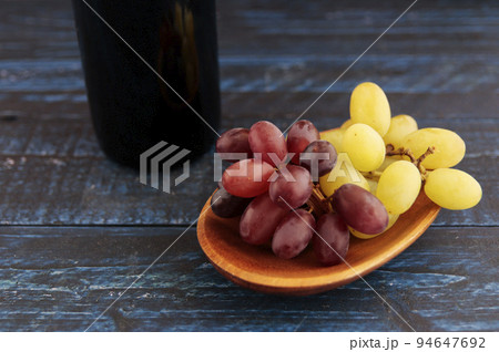 テーブルにあるアルコールのワインの原材料になるぶどう 94647692
