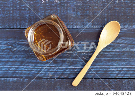 テーブルにある瓶に入ったロイヤルゼリーたっぷりの美容になるはちみつ テーブルにある瓶に入ったロイヤルゼリーたっぷりの美容になるはちみつ 94648428