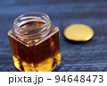 テーブルにある瓶に入ったロイヤルゼリーたっぷりの美容になるはちみつ 94648473