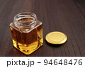 テーブルにある瓶に入ったロイヤルゼリーたっぷりの美容になるはちみつ 94648476