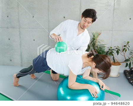 パーソナルトレーナーにプランクの指導を受ける日本人女性 パーソナルトレーナーにプランクの指導を受ける日本人女性 94648620