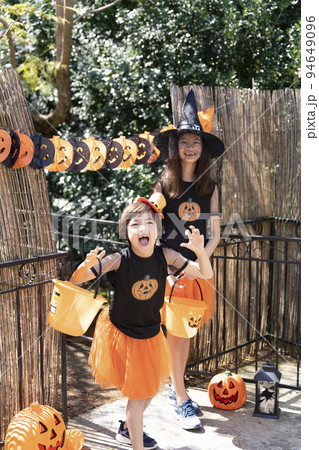 ハロウィンのコスチュームを着てトリックオアトリートをしている女の子2人 94649096